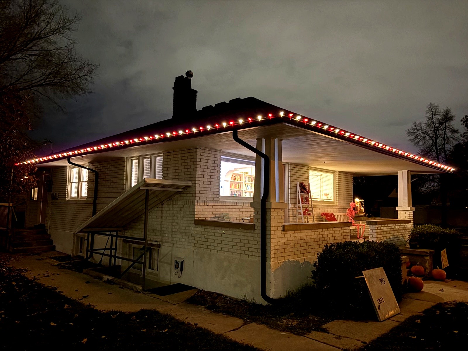 White brick home with alternating red and white roofline lights