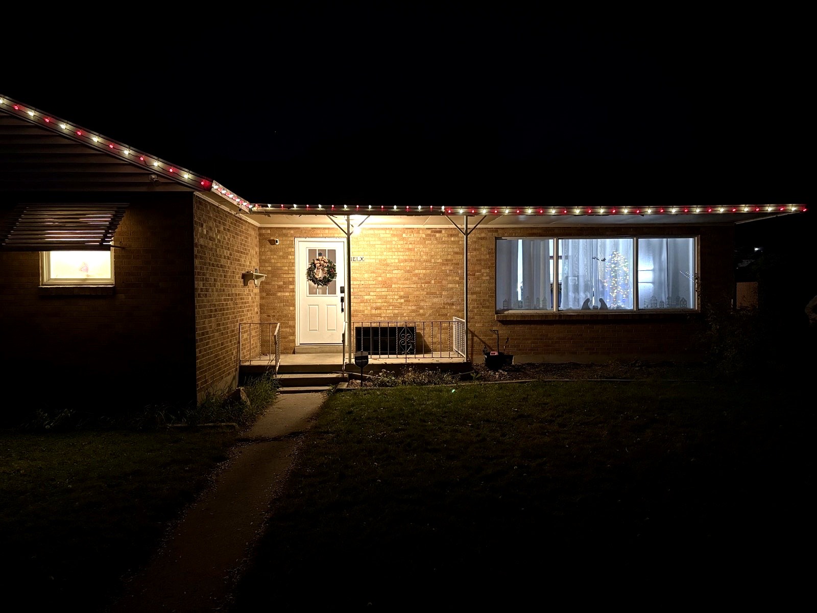Ranch-style home with red and white roofline lights